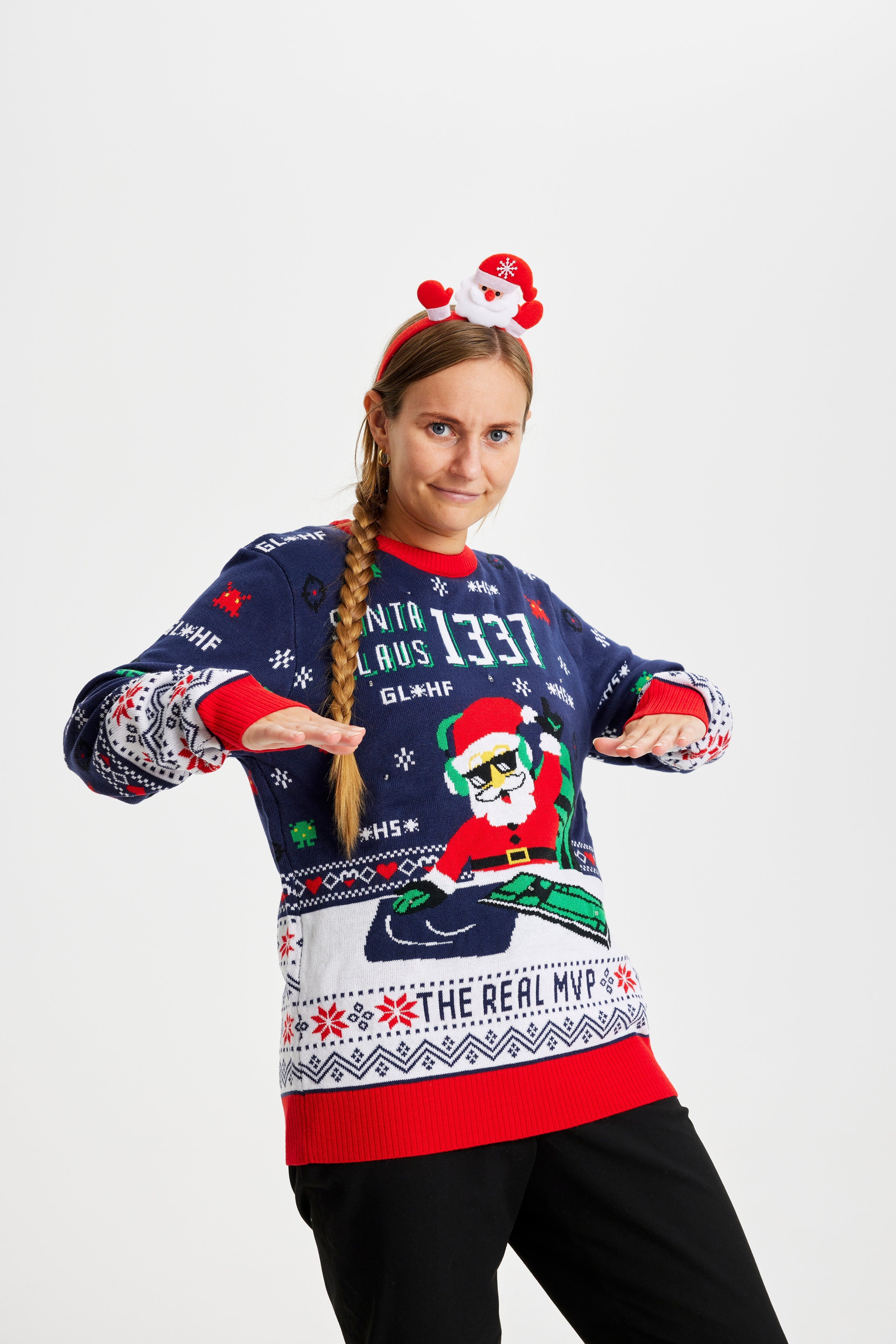 Eine feiernde Frau in einem Weihnachtspulli mit dem Spruch